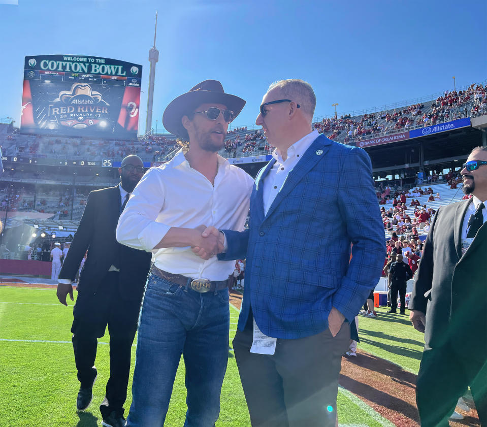 SEC commissioner Greg Sankey shakes hands with actor Matthew McConaghey before the annual Texas-Oklahoma rivalry game. (Credit: Yahoo Sports)