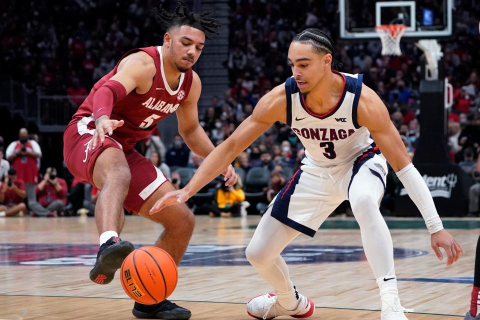 Alabama's Jaden Shackelford, left, tries to get a foot on the ball as Gonzaga's Andrew Nembhard reaches for the ball during the first half of an NCAA college basketball game Saturday, Dec. 4, 2021, in Seattle. (AP Photo/Elaine Thompson)