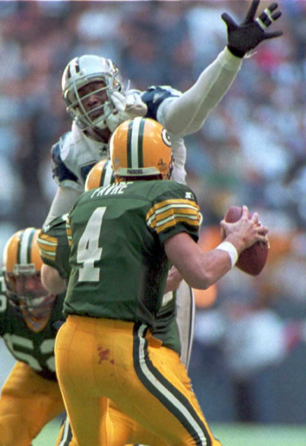 Green Bay Packers quarterback Brett Favre is pressured by Dallas Cowboys defensive end Charles Haley during the NFC divisional playoff game at Texas Stadium in Irving, Texas, in January 1995.
