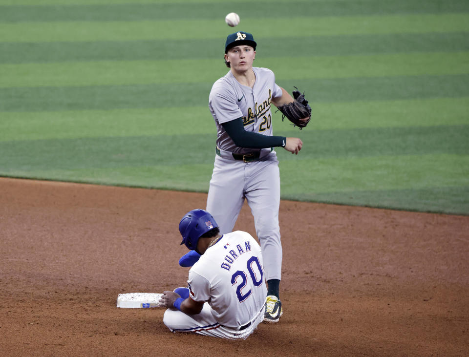 Oakland Athletics second base Zack Gelof, top, starts a double play as Texas Rangers first base Ezequiel Duran, bottom, slides into the base during the fifth inning of a baseball game Thursday, April 11, 2024, in Arlington, Texas. (AP Photo/Michael Ainsworth)