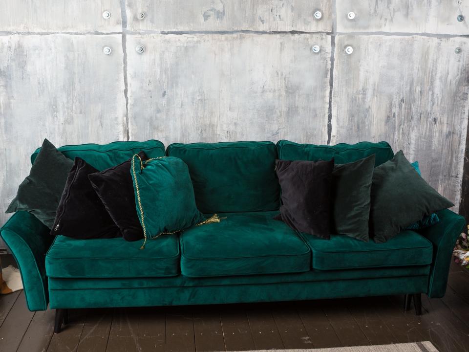 green velvet couch simple walls throw pillows