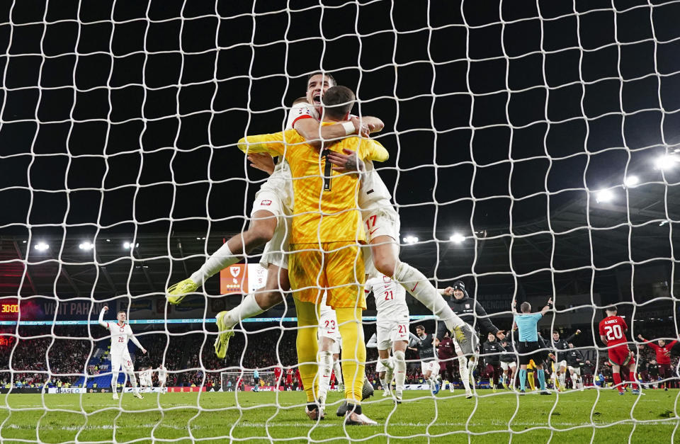 Los jugadores de Polonia abrazan al arquero Wojciech Szczesny, quien atajó el penal decisivo en la tanda ante Gales durante un encuentro del repechaje hacia la Eurocopa, el martes 26 de marzo de 2024, en Cardiff (David Davies/PA via AP)