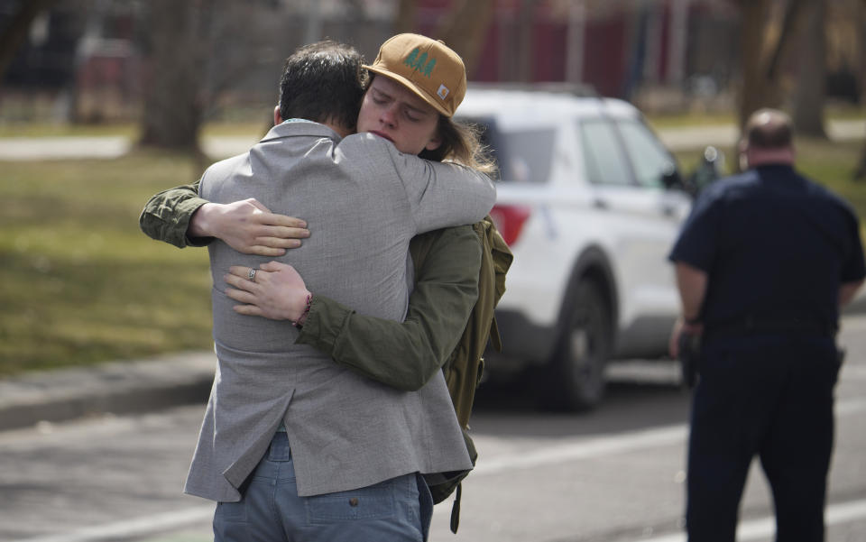 A student, right, hugs a man after a school shooting at East High School Wednesday, March 22, 2023, in Denver. (AP Photo/David Zalubowski)