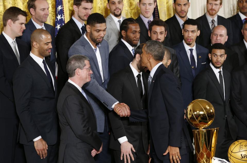 U.S. President Barack Obama shakes hands with forward Tim Duncan as he honors the NBA defending champion San Antonio Spurs basketball team at the White House in Washington January 12, 2015. REUTERS/Kevin Lamarque (UNITED STATES - Tags: POLITICS SPORT BASKETBALL)