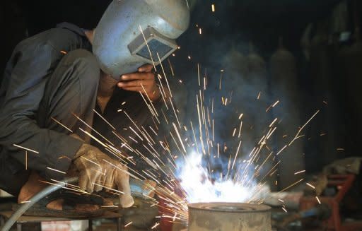 An Indian labourer welds metal in an industrial area of Mumbai. India's industrial output growth rebounded by a surprise 2.4 percent in May after shrinking the previous month, data showed Thursday, bringing some cheer after a string of gloomy economic numbers