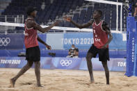 Cherif Younousse, right, of Qatar, and teammate Ahmed Tijan celebrate a play during a men's beach volleyball quarterfinal match against Italy at the 2020 Summer Olympics, Wednesday, Aug. 4, 2021, in Tokyo, Japan. (AP Photo/Petros Giannakouris)