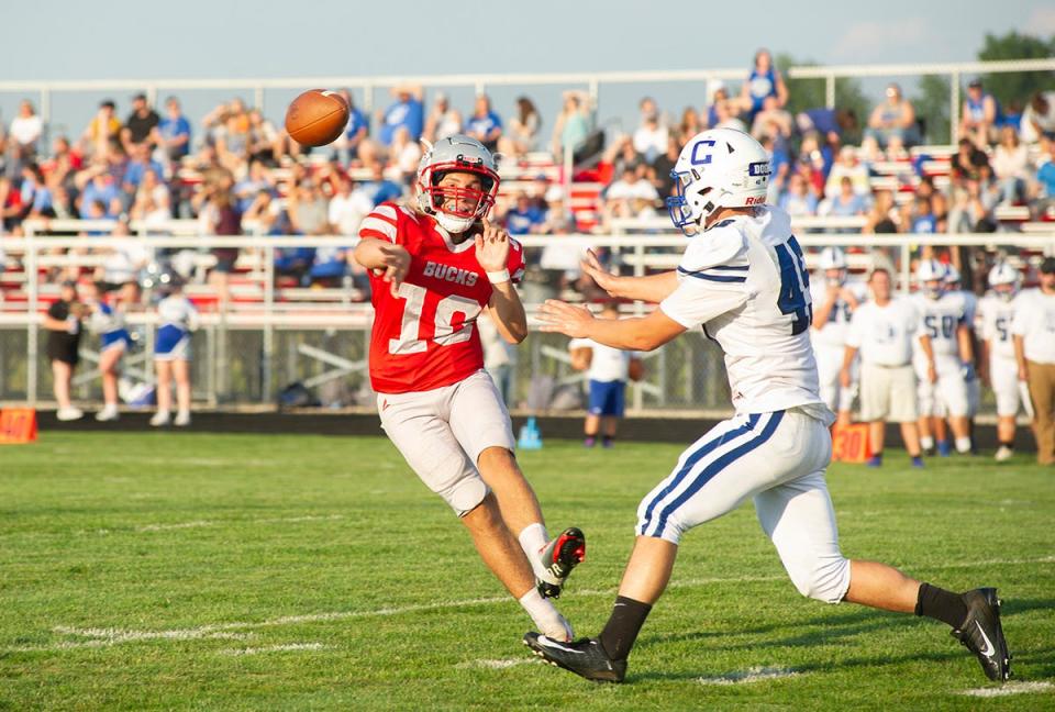 Buckeye Central's Derex Dean slings a pass to a receiver out wide as Crestline's Jake Bruce closes in.