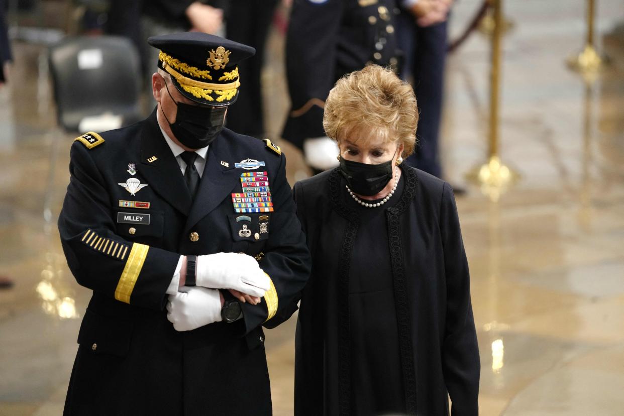 Elizabeth Dole, the wife of former US senator Bob Dole, escorted by Chairman of the Joint Chiefs of Staff General Mark Milley, follows her husband's casket into the US Capitol in Washington, DC where it will lie in state on December 9, 2021.