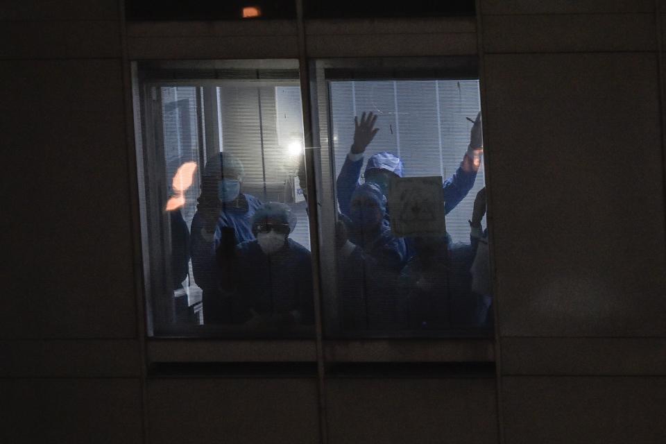 Medical personnel from the "20 de Noviembre" hospital wave back to residents across the street singing to praise them and their patients in Mexico City, on April 28, 2020, amid the novel coronavirus pandemic. - Latin America is like "Europe six weeks ago" in relation to the advance of COVID-19, so an increase in the number of cases is expected in the coming weeks, warned on April 28 the deputy director of the Pan American Health Organization (PAHO), Jarbas Barbosa. (Photo by PEDRO PARDO / AFP) (Photo by PEDRO PARDO/AFP via Getty Images)