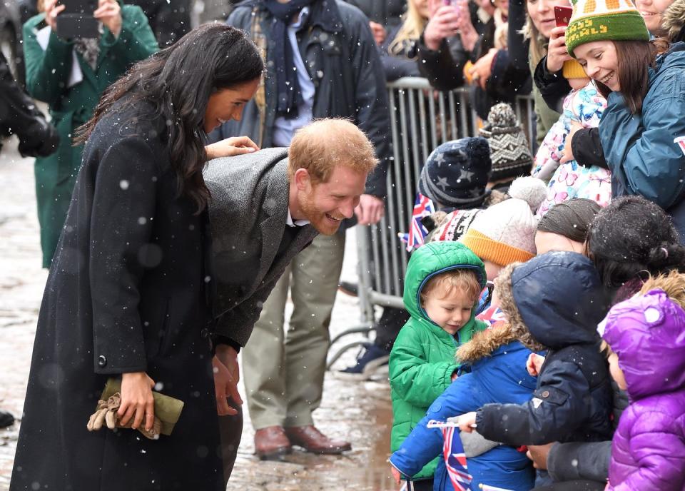 Harry and Meghan smile as they greet children in Bristol