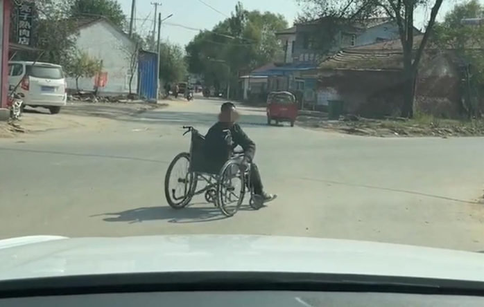 大陸河南省濮陽市一名獨居的殘疾男子，日前竟多次坐著輪椅衝到路中朝車輛索財。（圖／截取自極目新聞網頁）