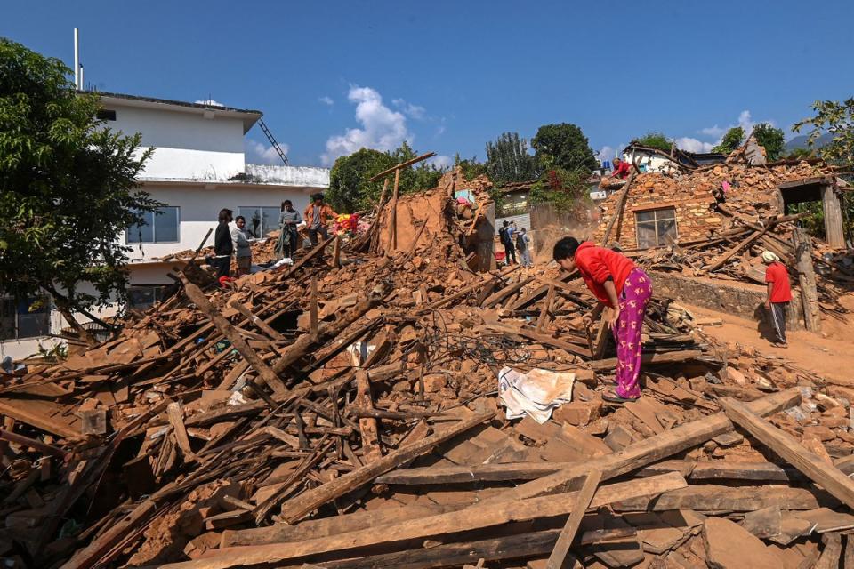 Survivors search for their belongings through the ruins of damaged houses following an earthquake in Khalanga of Jajarkot district, Nepal (AFP via Getty Images)