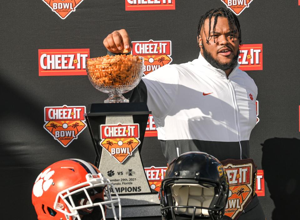Clemson defensive tackle Payton Page grabs some crackers from the championship trophy during the Cheez-It Bowl Day for Kids at Fun Spot America theme park in Orlando, Florida Monday, December 27, 2021. 
