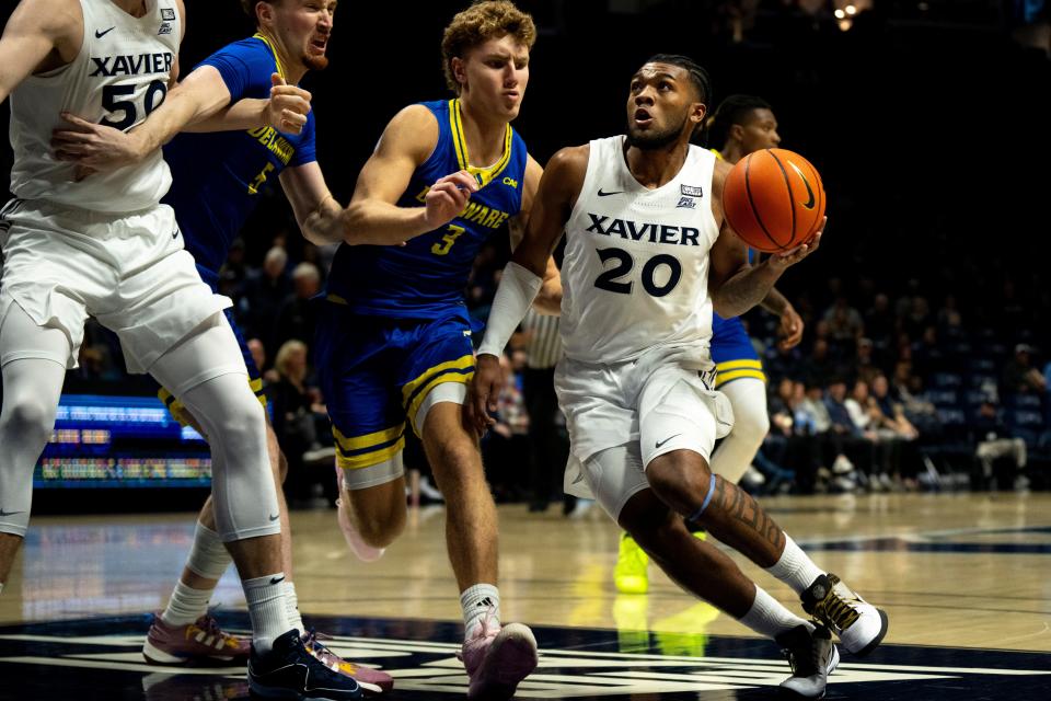 Xavier Musketeers guard Dayvion McKnight (20) drives on Delaware Blue Hens guard Cavan Reilly (3) in the first half of the NCAA basketball game between the Delaware Blue Hens and the Xavier Musketeers at the Cintas Center in Cincinnati on Tuesday, Dec. 5, 2023.