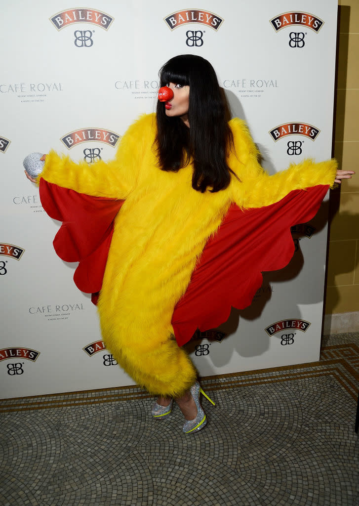 Jameela poses in a chicken suit with high heels at an event