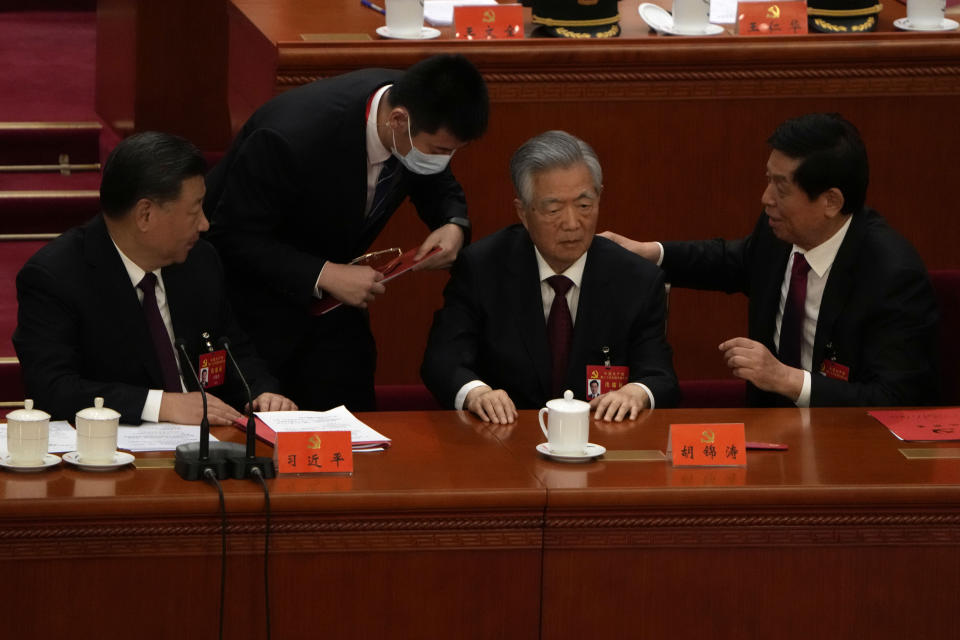 Chinese President Xi Jinping at left looks on as former Chinese President Hu Jintao is assisted to leave the hall during the closing ceremony of the 20th National Congress of China's ruling Communist Party at the Great Hall of the People in Beijing, Saturday, Oct. 22, 2022. Former Chinese President Hu Jintao, Xi's predecessor as party leader, was helped off the stage shortly after foreign media came in, sparking speculation about his health. (AP Photo/Ng Han Guan)