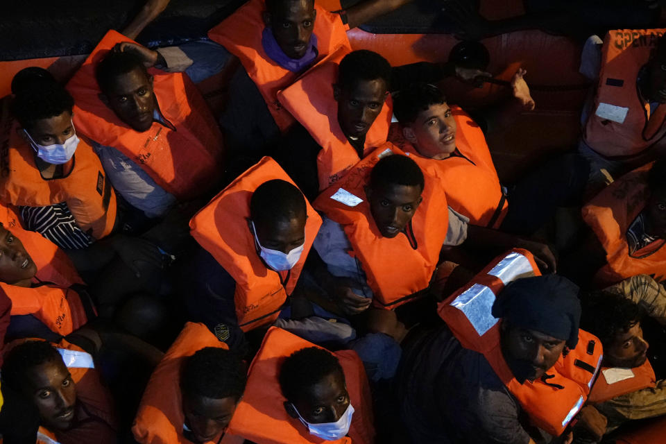 Migrants rescued by the Spanish NGO Open Arms in the Mediterranean sea huddle in a boat early Sunday, Sept. 18, 2022. Around 200 migrants from Syria and Africa countries were rescued by NGO Open Arms crew members. (AP Photo/Petros Karadjias)