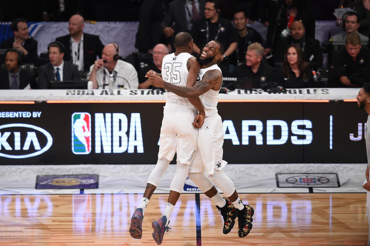 LeBron James and Kevin Durant embrace during the 2018 NBA All-Star Game, probably because they just remembered all those flaming hot bars they spit in the summer of 2011. (AFP)