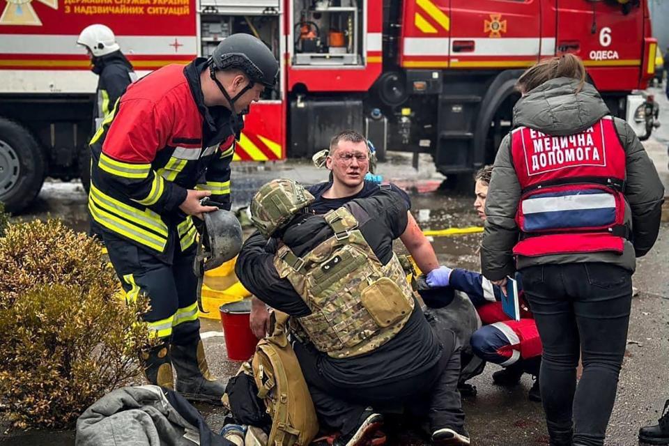 In this photo provided by the Ukrainian Emergency Service, emergency services help their comrade injured during a Russian attack in Odesa, Ukraine, Friday, March 15, 2024.