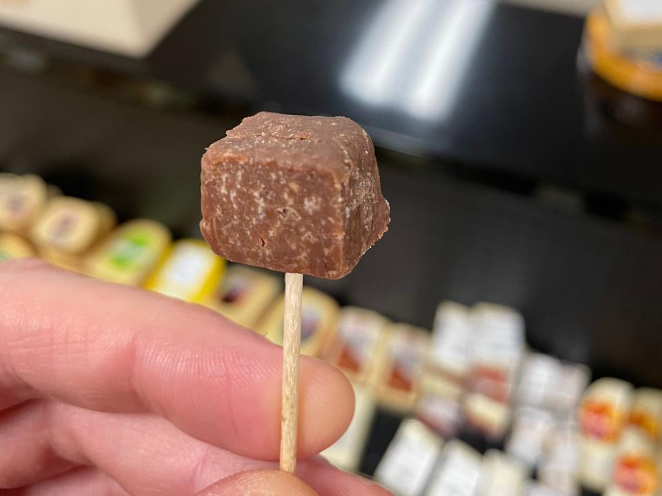 keith holding up a sample of chocolate cheese from mars cheese castle in wisconsin