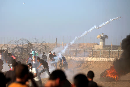 Palestinians run from tear gas during a protest calling for lifting the Israeli blockade on Gaza and demanding the right to return to their homeland, at the Israel-Gaza border fence, in the southern Gaza Strip September 21, 2018. REUTERS/Ibraheem Abu Mustafa