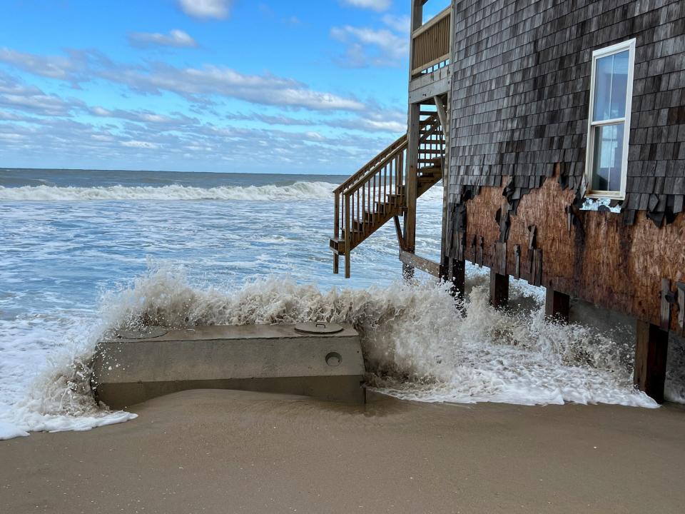 Waves crash over the septic tank of a water-damaged house in Rodanthe in December 2022.