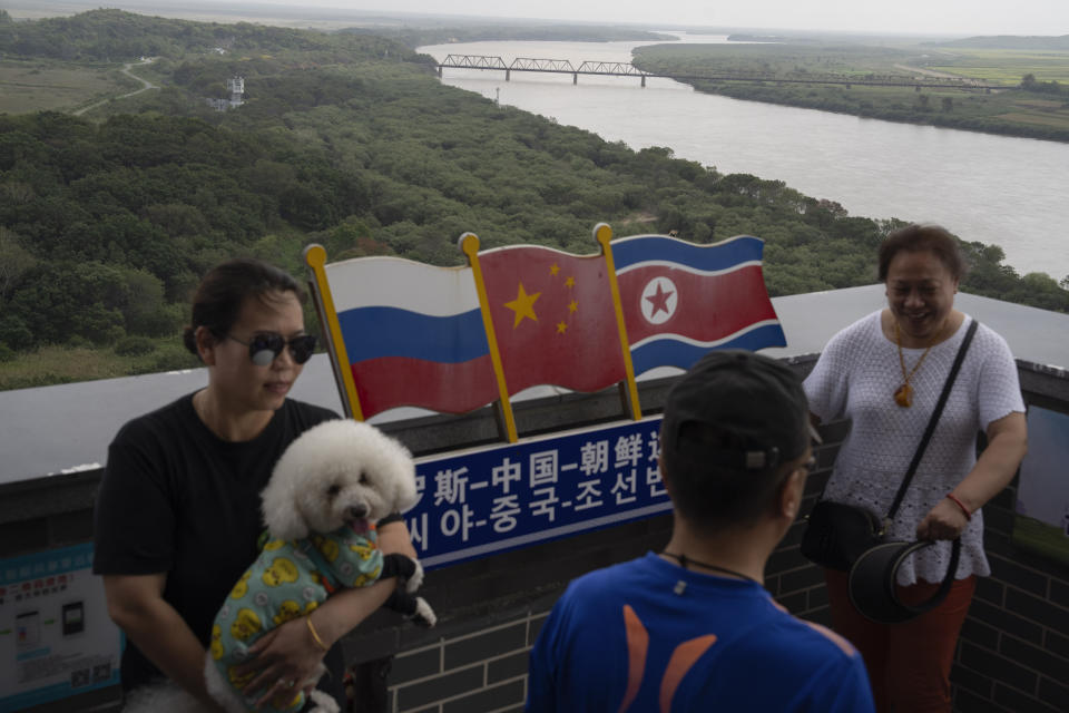 A visitor carries her pet up to the Yiyanwang Three Kingdoms viewing platform that looks over into the North Korean and Russian borders across from Fangchuan in northeastern China's Jilin province on Monday, Sept. 11, 2023. Russia and North Korea confirmed Monday that North Korean leader Kim Jong Un will visit Russia in a highly anticipated meeting with President Vladimir Putin that has sparked Western concerns about a potential arms deal for Moscow's war in Ukraine. (AP Photo/Ng Han Guan)