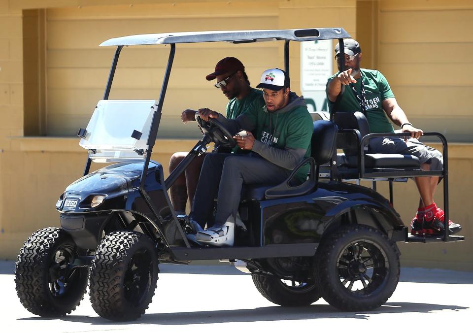 Browns cornerback Denzel Ward and former Ohio State quarterback/wide receiver Braxton miller arrive to a football skills camp at STVM High School in a golf cart on Thursday.