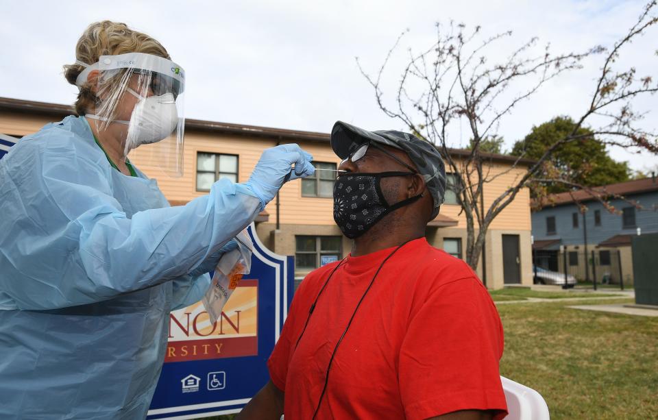 Toni Gomacki performs a coronavirus test on Curtis Morrow, of Erie, outside the John Horan Apartments on Erie's east side Sept. 29. The free tests were provided by Latino Connection, a Harrisburg-based Latino and minority outreach company. The mobile unit, called CATE, provided 100 tests in Erie, and another 100 were available later in the day in Corry.