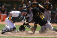 Oakland Athletics catcher Kyle McCann, left, tags out Pittsburgh Pirates' Oneil Cruz at home during the fourth inning of a baseball game in Oakland, Calif., Wednesday, May 1, 2024. (AP Photo/Jeff Chiu)