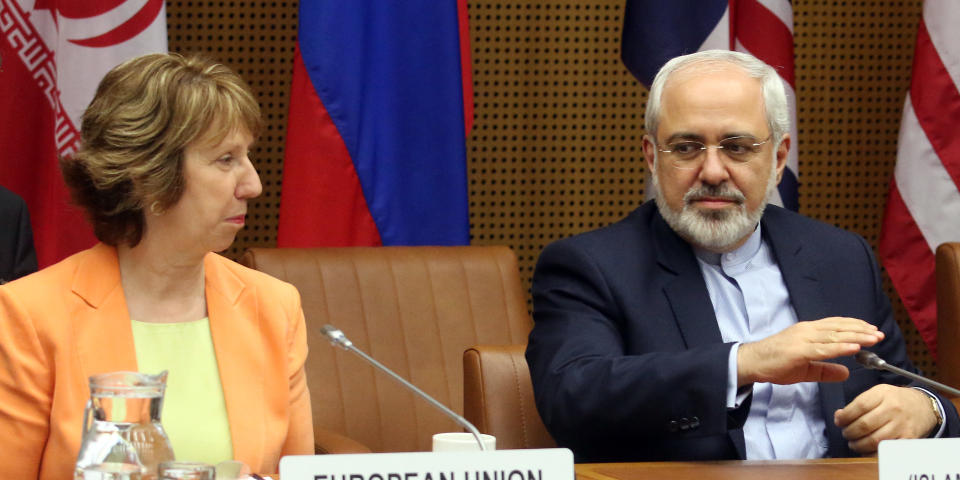 European foreign policy chief Catherine Ashton, left, and Iranian Foreign Minister Mohamad Javad Zarif, right, wait for the start of closed-door nuclear talks in Vienna, Austria, Wednesday, March 19, 2014. Iran and six world powers appear to be tackling less sensitive issues first at nuclear talks meant to curb Tehran's atomic activities in exchange for full sanctions relief. Iran's official IRNA news agency says Wednesday's talks are focusing on a heavy water reactor. The six want the nearly finished reactor shut down, or converted to a type that produces less plutonium, a material that could be used to make nuclear weapons. (AP Photo/Ronald Zak)