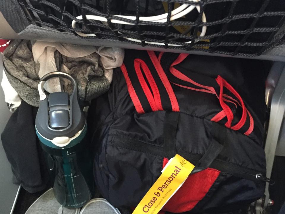 Catherine Smith's personal belongings tucked under the plane seat in front of her.