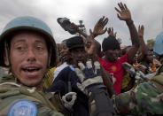 <p>United Nations soldiers from Uruguay hold the crowd back during a food distribution in Port-au-Prince, Monday, Jan. 25, 2010. (Photo: Ramon Espinosa/AP) </p>