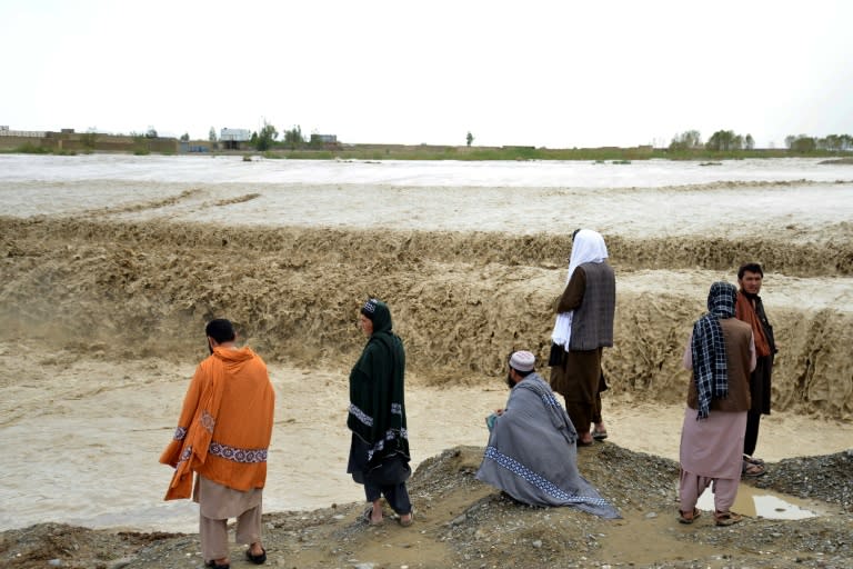 Un grupo de afganos observa una zona inundada en el distrito de Spin Boldak, en la provincia de Kandahar, el 13 de abril de 2024 (Sanaullah Seiam)