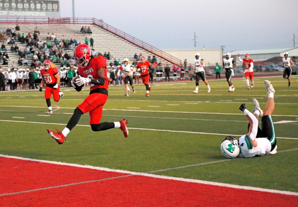 Carl Albert's Trystan Haynes scores a touchdown in front of McGuinness' Jack Foster during the high school football game between Carl Albert and Bishop McGuinness at Carl Albert High School in Midwest City, Okla., Friday, Oct., 13, 2023.