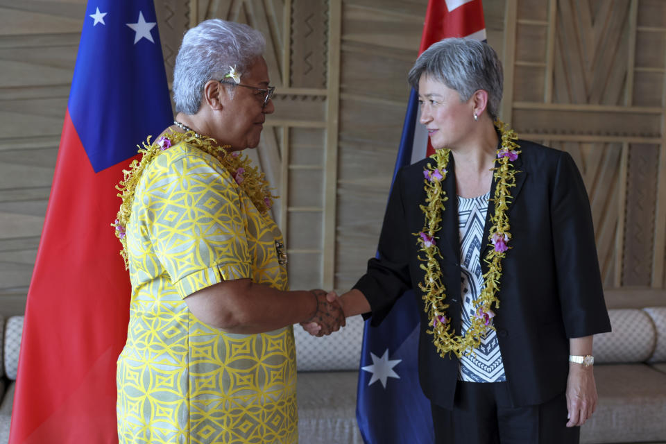 In this photo supplied by the Australian Department of Foreign Affairs, Australian Foreign Minister Penny Wong, right, shakes hands with Samoa's Prime Minister Fiame Naomi Mata’afa in Apia, Samoa, Thursday, June 2, 2022. (Australian Department of Foreign Affairs via AP)