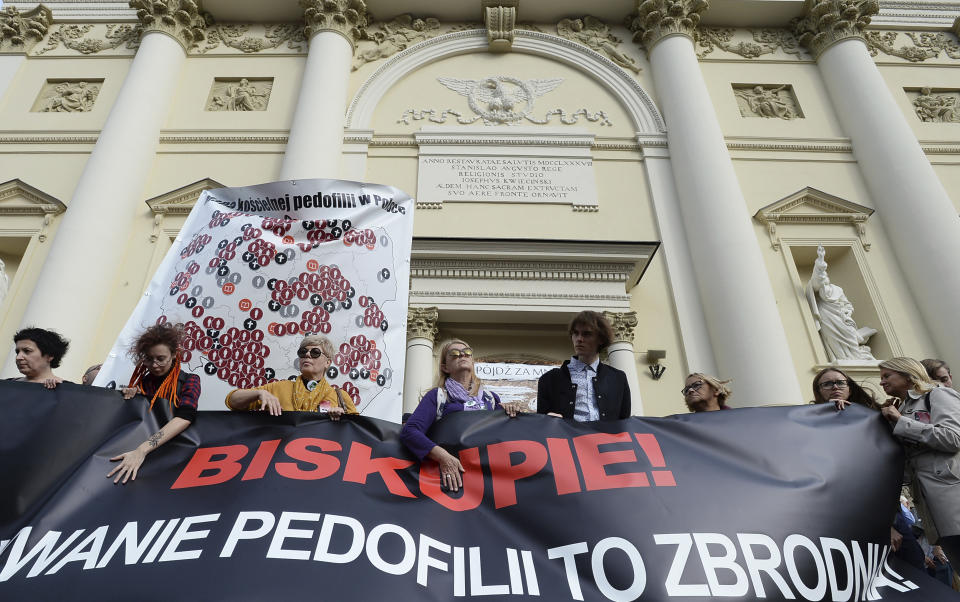 Protesters holding a map of Poland with 255 documented cases of sexual abuse of minors by the country's Catholic priests, stop in front of St. Anna church as they march in Warsaw, Poland, Sunday, Oct. 7, 2018, demanding Poland's church leaders to stop protecting pedophile priests. The writing on the banner reads: "Bishop. Hiding Pedophilia is a Crime." (AP Photo/Alik Keplicz)