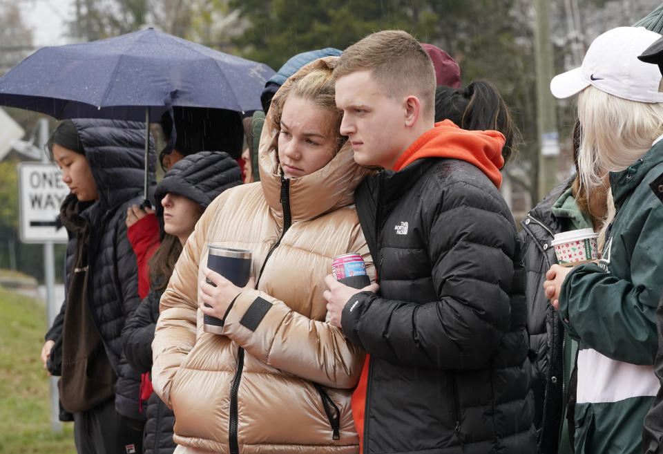 Mourners look over flowers that line a bridge near the scene of a shooting on the grounds of the University of Virginia Tuesday Nov. 15, 2022, in Charlottesville. Va. Authorities say three people have been killed and two others were wounded in a shooting at the University of Virginia and a student suspect is in custody. (AP Photo/Steve Helber)