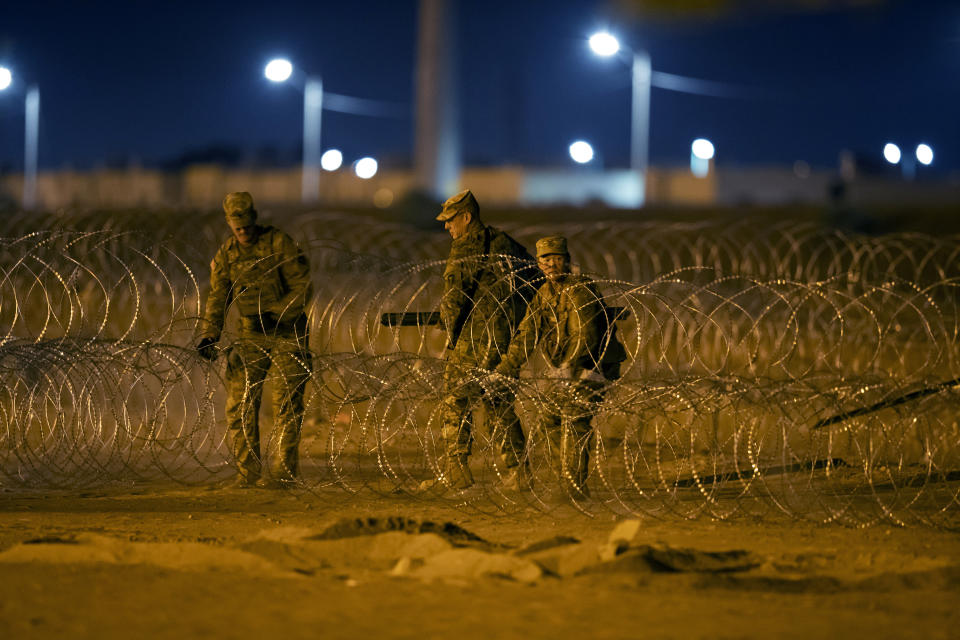 Texas National Guard soldiers install new rows of barbed-wire near a gate at the border fence in El Paso, Texas, in the early hours of Thursday, May 11, 2023. Migrants rushed across the border hours before pandemic-related asylum restrictions were to expire Thursday, fearing that new policies would make it far more difficult to gain entry into the United States. (AP Photo/Andres Leighton)