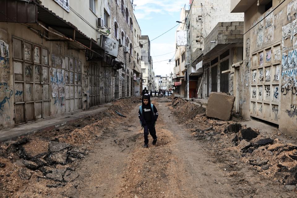 A Palestinian child walks on a street which has been bulldozed by the Israeli forces during a raid in Jenin in the occupied West Bank on January 29, 2024.