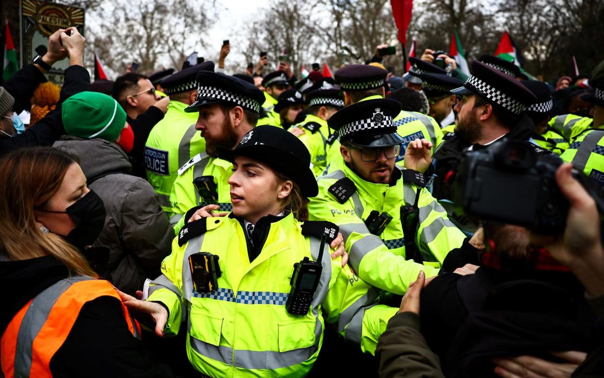 Police officers hold back protesters calling for a ceasefire in Gaza during a Pro-Palestinian demonstration in central London on Jan 6