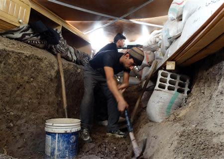 A Free Syrian Army fighter digs a trench as protection from forces loyal to Syria's President Bashar al-Assad in the eastern al-Ghouta, near Damascus September 8, 2013. Picture taken September 8, 2013. REUTERS/Msallam Abd Albaset