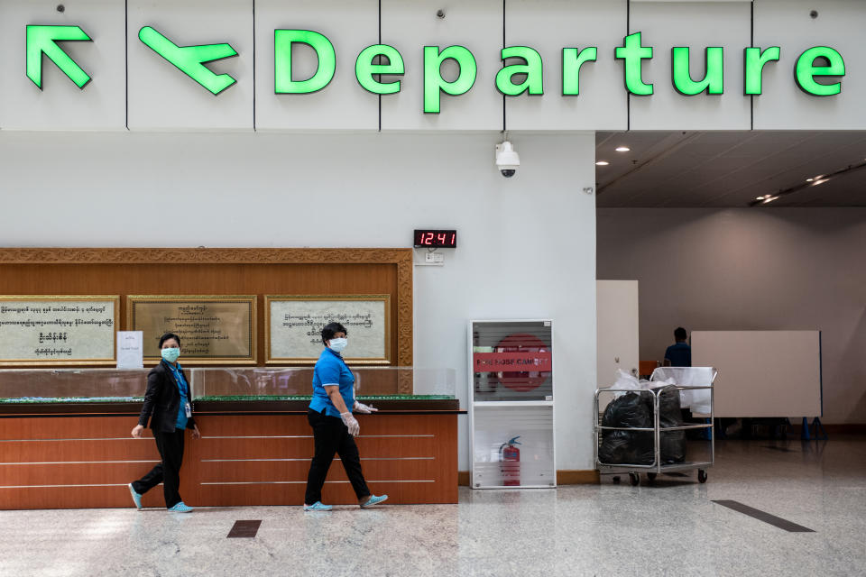 Airport staffs wearing face masks, amid concerns of the COVID-19 coronavirus, walking through departure area at Yangon international airport in Yangon on March 18, 2020. (Photo by Shwe Paw Mya Tin/NurPhoto via Getty Images)