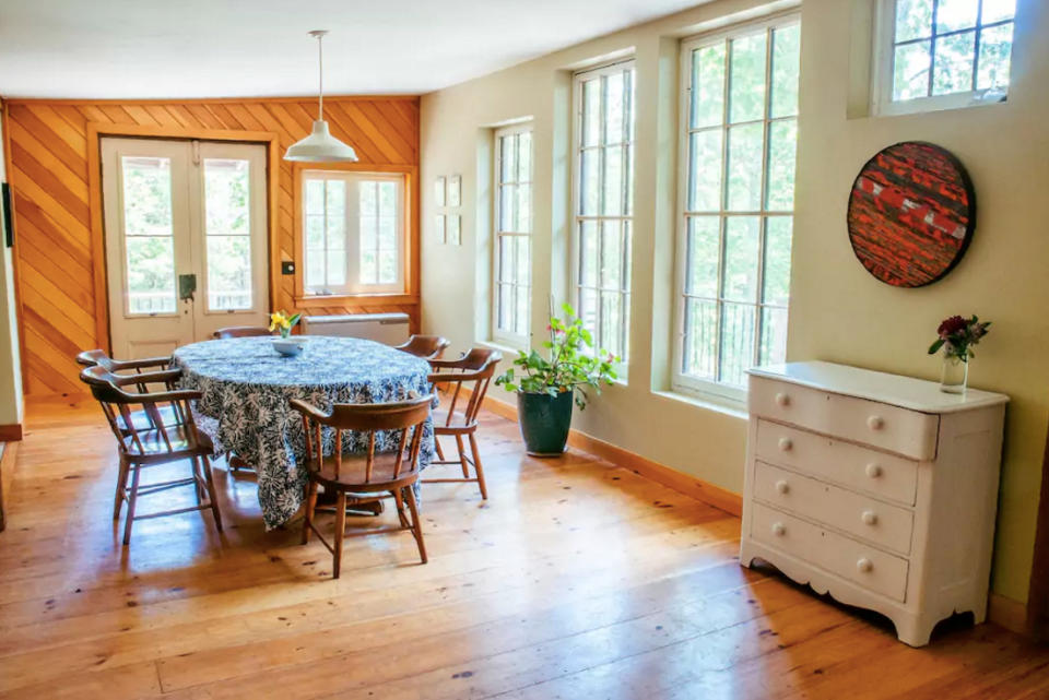 <p>Here’s the dining room with beautiful wood floors and double doors that open up to the deck. (Airbnb) </p>