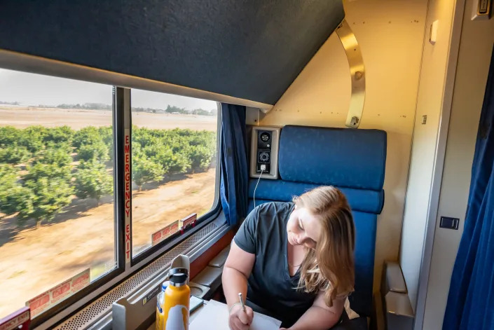 Molly Allen journaling on Coast Starlight Amtrak train