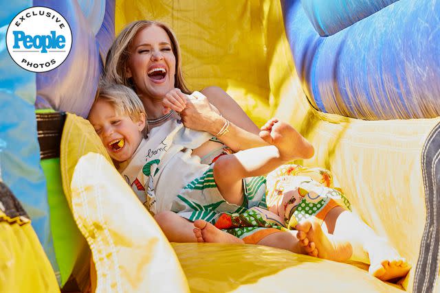 <p>Nicole Hill Gerulat/@NicoleGerulat</p> Angie Harrington goes down the slide with son Hart