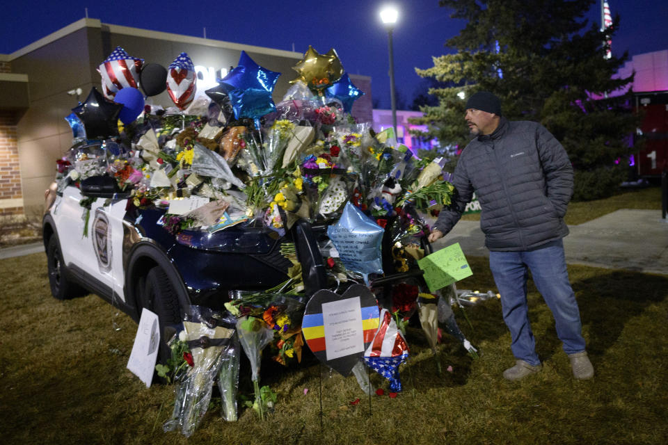 Jacob Swartout, a Sergeant with Savage Police, bumps his fist against the bumper of a fallen officer's squad car Tuesday, Feb. 20, 2024 outside the Burnsville Police Station in Burnsville, Minn. Two young police officers and a firefighter-paramedic were killed in a burst of gunfire Sunday as they responded to a domestic disturbance call in the Minneapolis suburb of Burnsville. Another officer also was injured, and the man identified as the shooter fatally shot himself, police said. (Aaron Lavinsky/Star Tribune via AP)