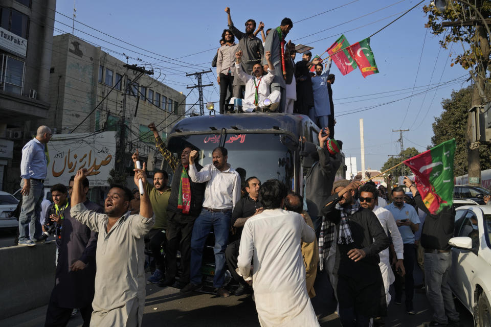 Supporters of Pakistan's former prime minister Imran Khan's 'Pakistan Tehreek-e-Insaf' party climb on a police van and chat ant government slogans during a rally, in Lahore, Pakistan, Wednesday, Feb. 22, 2023. Hundreds of supporters of Pakistan's former prime minister on Wednesday defied a ban on rallies in a commercial area of the city of Lahore, taunting police and asking to be arrested en masse. (AP Photo/K.M. Chaudary)