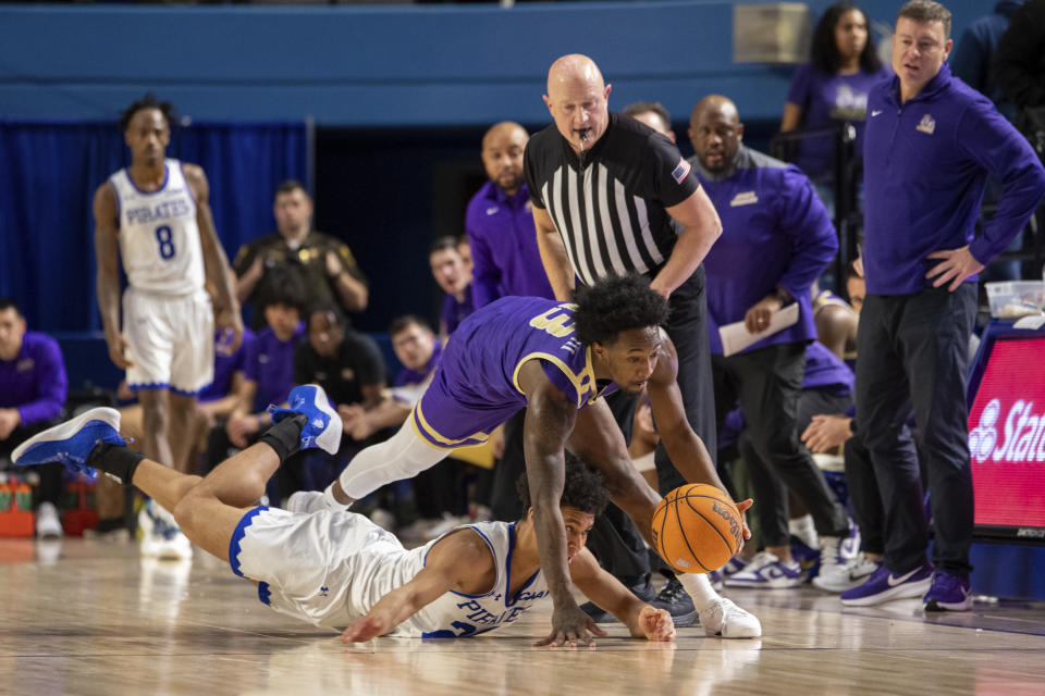 James Madison guard Michael Green III, top, dives after a loose ball against Hampton guard Ford Cooper, bottom, during the first half of an NCAA college basketball game Saturday, Dec. 16, 2023, in Hampton, Va. (AP Photo/Mike Caudill)