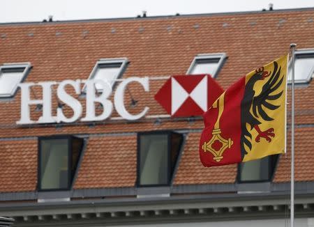 A HSBC logo is pictured behind the flag of the canton of Geneva at a Swiss branch of the bank in Geneva February 18, 2015. REUTERS/Denis Balibouse